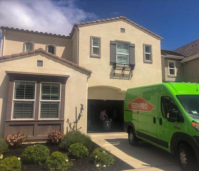 Green SERVPRO van parked in front of a home.